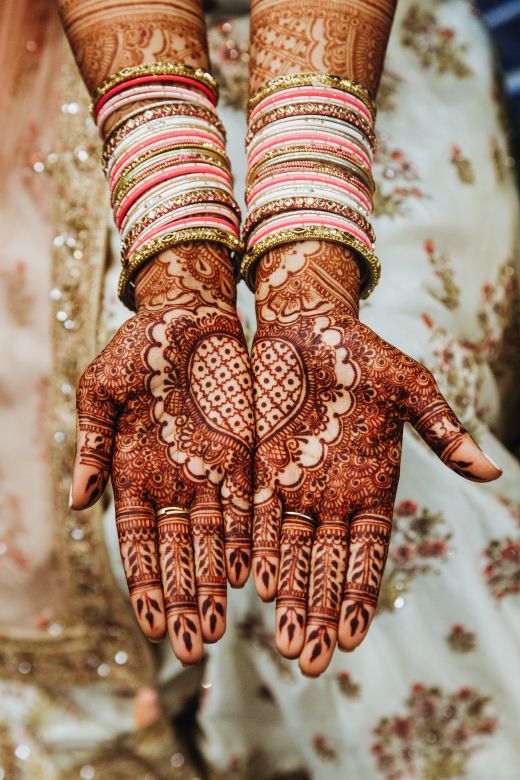 Indian wedding bangles mehandi henna coloured hands with reflective or - bridal mehndi design