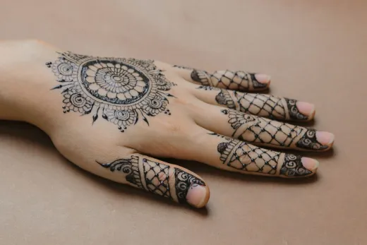 Close up of a hand adorned with detailed henna - henna tattoo
