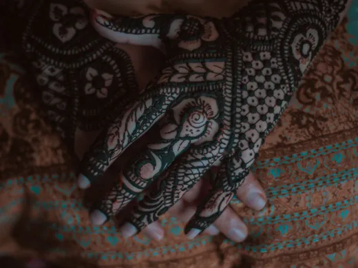 Close up of hands adorned with intricate henna - henna tattoo