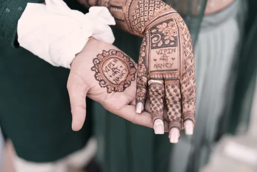 Close up of henna tattoos on a couple s hands - mehndi design