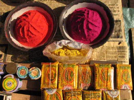 Brightly colored holi powders on a market stal - henna paste