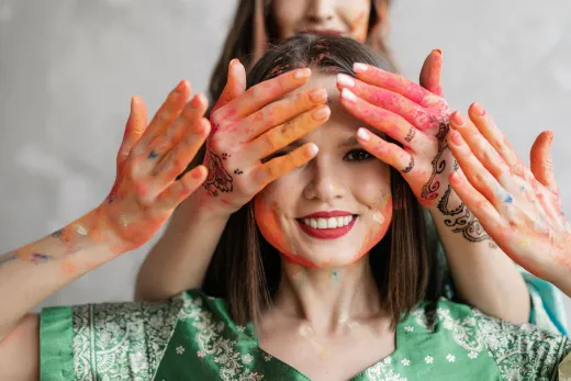 Smiling woman enjoying holi festival with vibr - henna paste