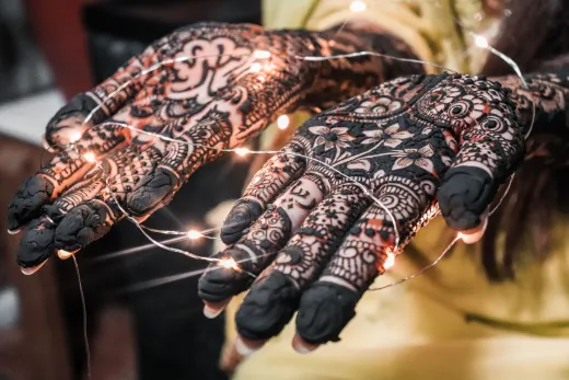 Close up of hands adorned with intricate henna - henna design