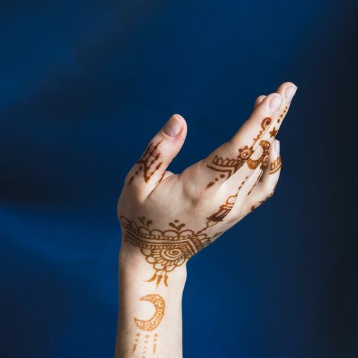 Hand with mehndi near blue textile - simple Arabic mehndi design